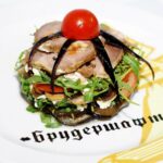 Melanzane a funghetto, piatto colorato con melanzane, pomodori e profumi mediterranei.