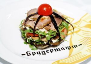 Melanzane a funghetto, piatto colorato con melanzane, pomodori e profumi mediterranei.