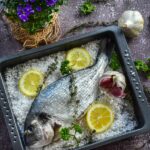 Pesce al sale sfilettato a tavola, mostrando la tecnica per preservare la polpa intatta.