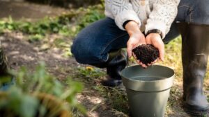 Un sacchetto di caffè macinato accanto a piante fiorite sul tavolo da giardino.