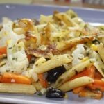 Pasta alla contadina cremosa servita in un piatto, decorata con verdure fresche e parmigiano grattugiato.