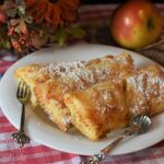 Frittelle di mele al forno, dorate e leggere, servite su un piatto bianco, pronte da gustare.