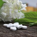 Aspirina disciolta in acqua mentre viene versata in un vaso di piante verdi.