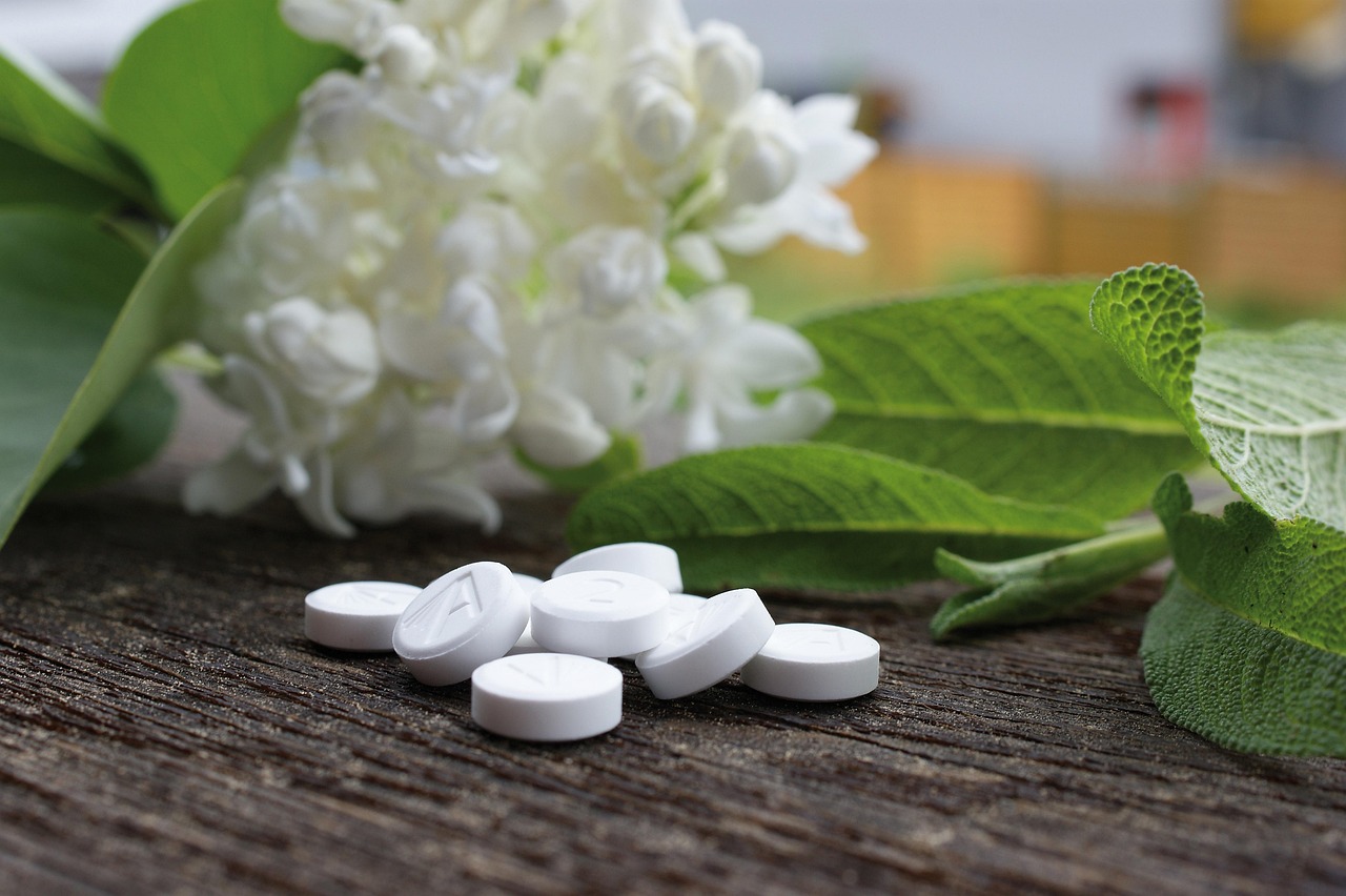 Aspirina disciolta in acqua mentre viene versata in un vaso di piante verdi.