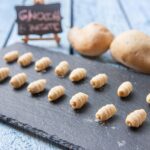 Gnocchi di patate freschi su un piano di lavoro, pronti per essere cotti e serviti.