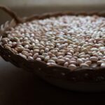 Piatto di pasta e fagioli servito in una ciotola, decorato con rosmarino fresco.