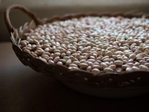 Piatto di pasta e fagioli servito in una ciotola, decorato con rosmarino fresco.